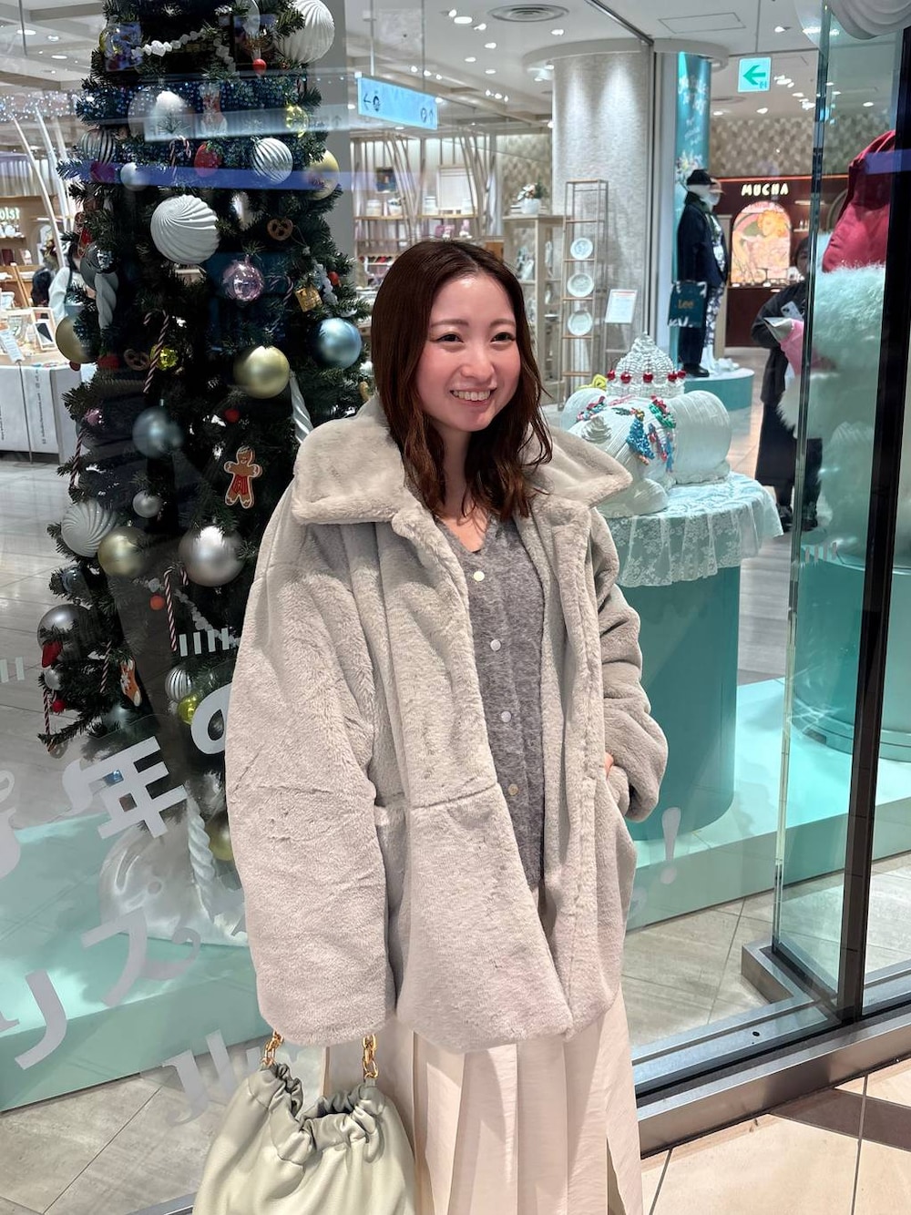 グレー系のその他アウター、グリーン系のショルダーバッグ、ホワイト系のスカートを着用したレディースの秋コーディネートの1枚目の写真