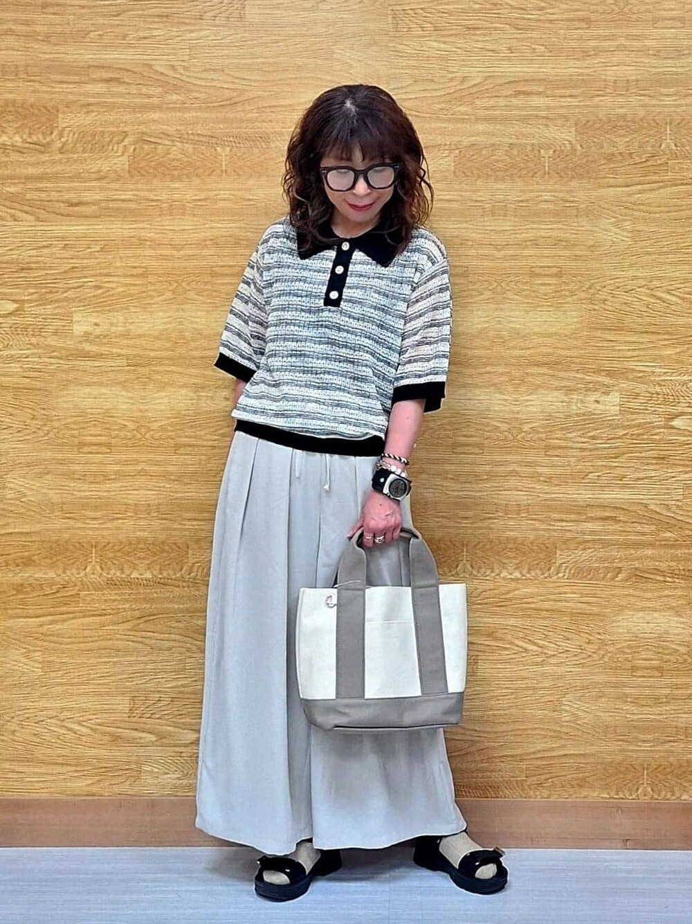 ベージュ系のその他パンツ、ブラック系のサンダル、ベージュ系のトートバッグを着用したレディースの春コーディネートの1枚目の写真
