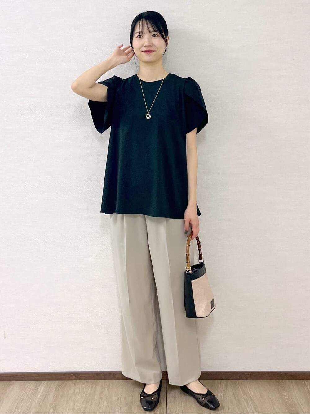 ブラック系のTシャツ/カットソー、ベージュ系のその他パンツ、ブラック系のショルダーバッグを着用したレディースの春コーディネートの1枚目の写真