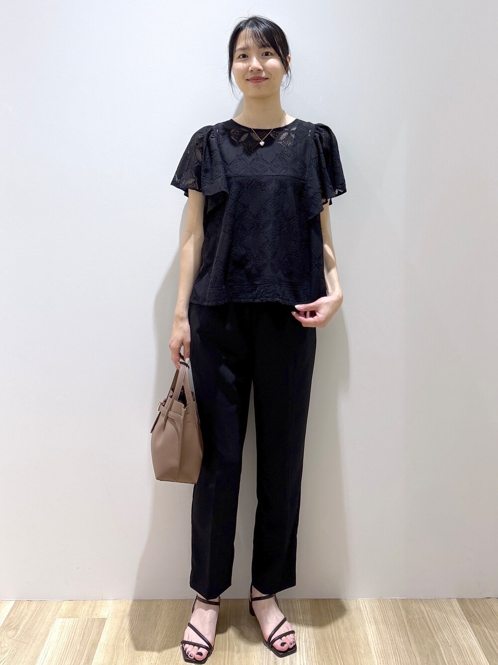 ブラック系のシャツ/ブラウス、ブラック系のその他パンツ、ブラウン系のトートバッグを着用したレディースの春コーディネートの1枚目の写真