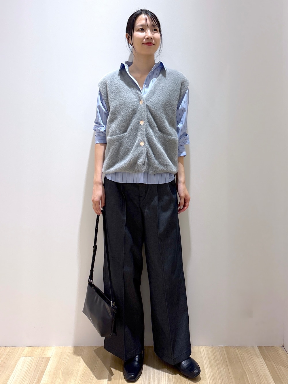 グレー系のニット/セーター、ブラック系のその他パンツ、ブラック系のショルダーバッグを着用したレディースの秋コーディネートの1枚目の写真