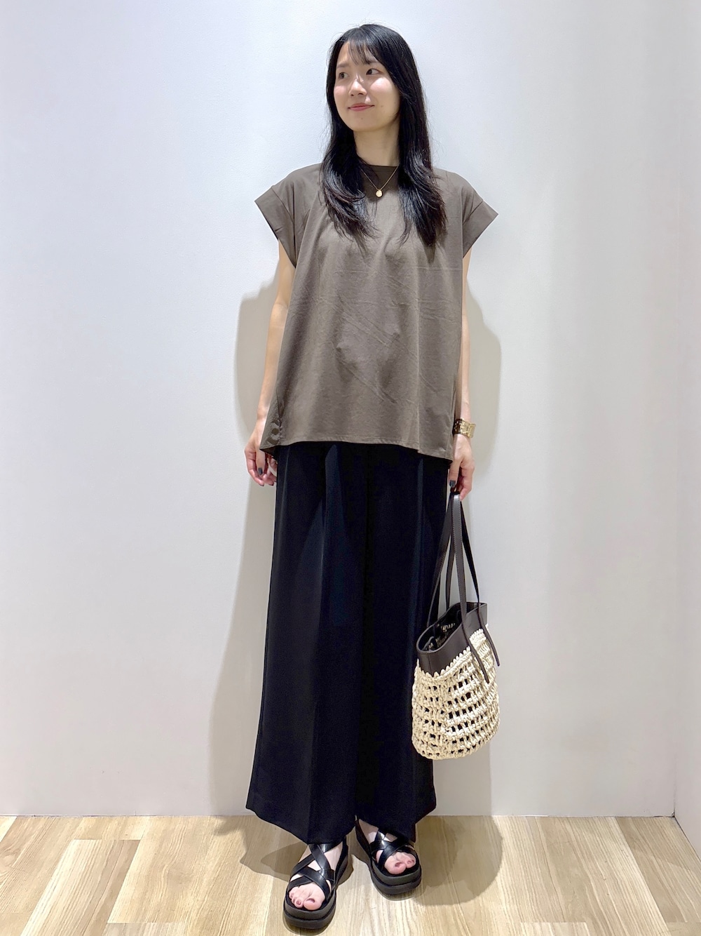 ブラウン系のTシャツ/カットソー、ブラック系のその他パンツ、ブラウン系のトートバッグを着用したレディースの夏コーディネートの1枚目の写真