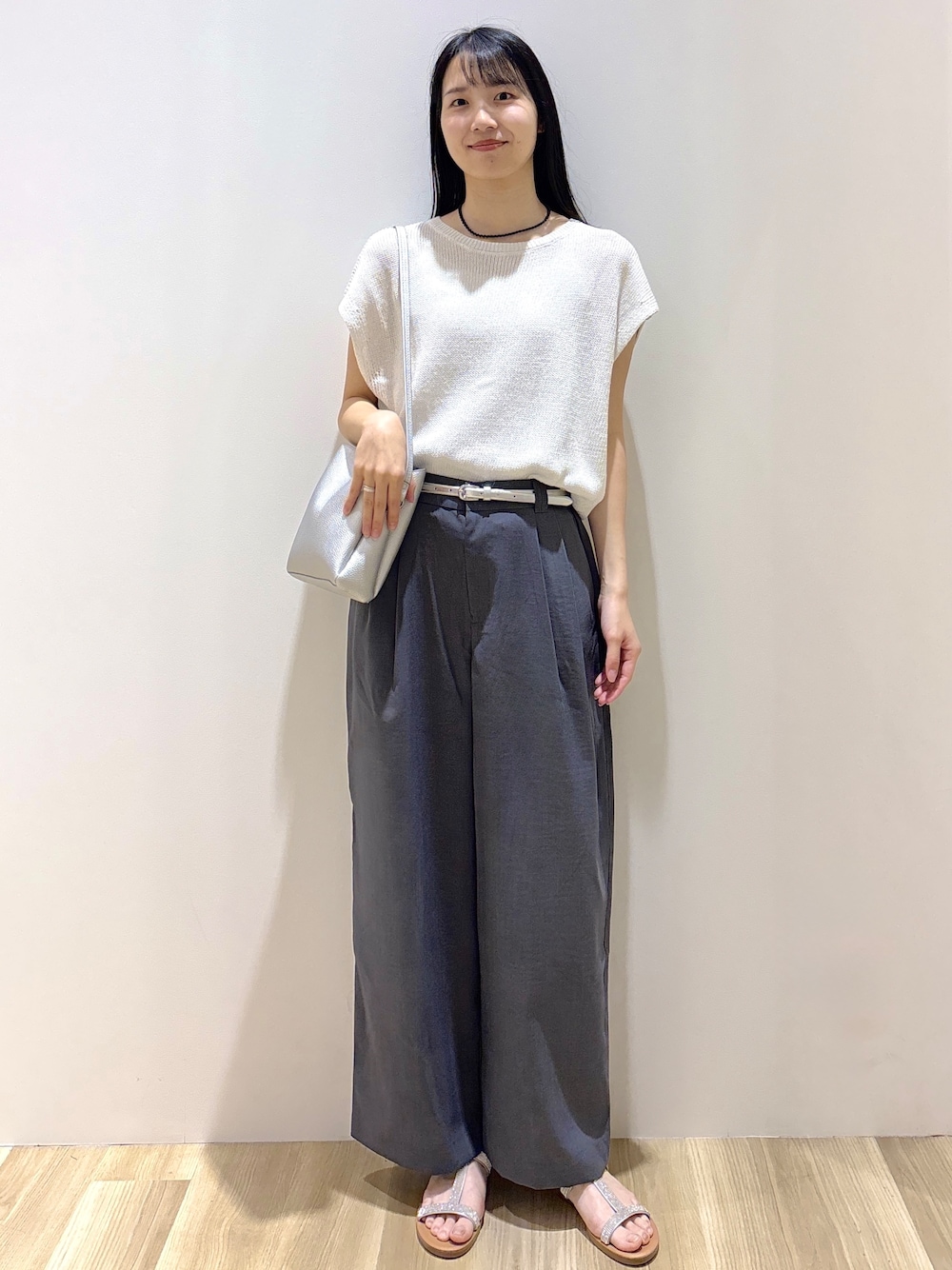 ホワイト系のニット/セーター、グレー系のその他パンツ、シルバー系のショルダーバッグを着用したレディースの夏コーディネートの1枚目の写真