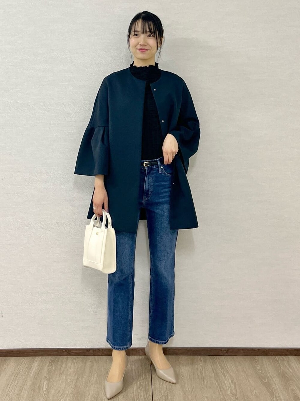 ブルー系のノーカラーコート、ブラック系のTシャツ/カットソー、ブルー系のデニムパンツを着用したレディースの冬コーディネートの1枚目の写真