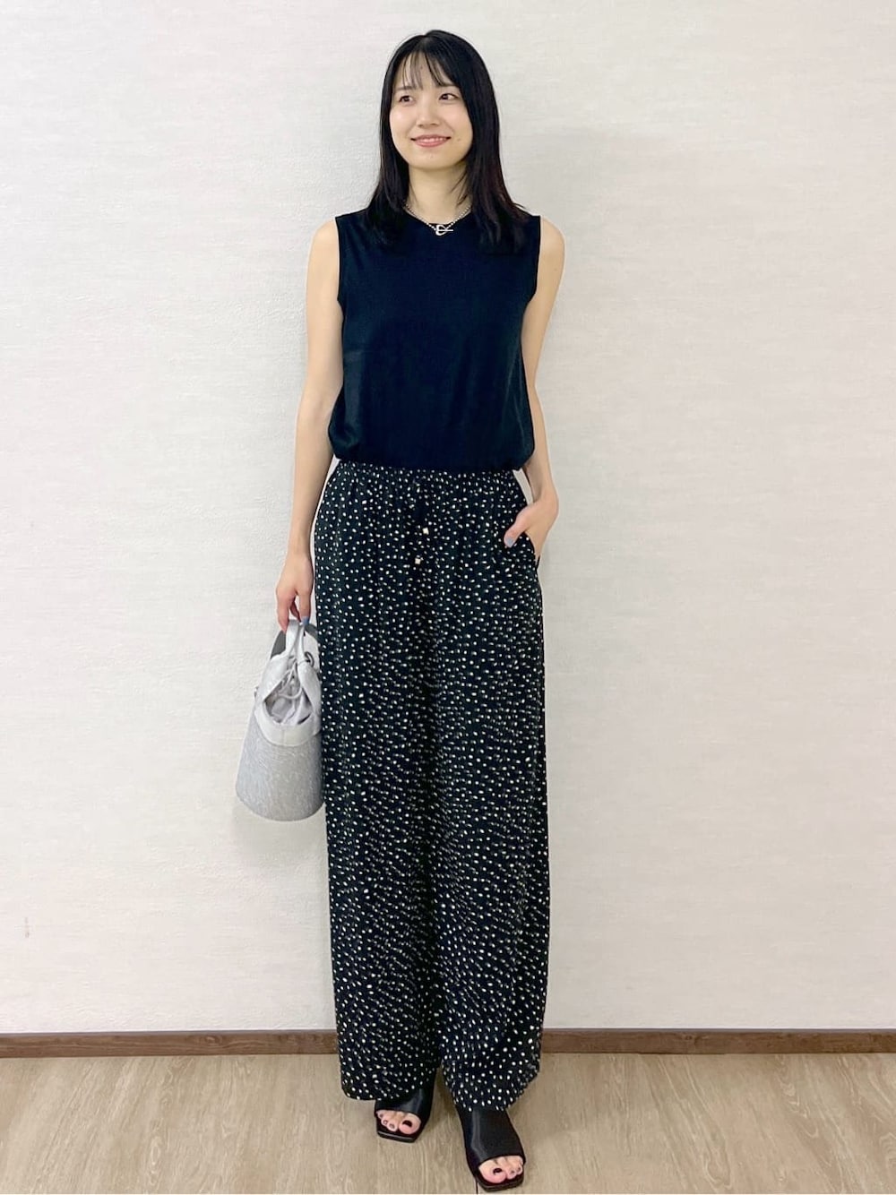 ブラック系のタンクトップ、ブラック系のその他パンツ、シルバー系のトートバッグを着用したレディースの夏コーディネートの1枚目の写真