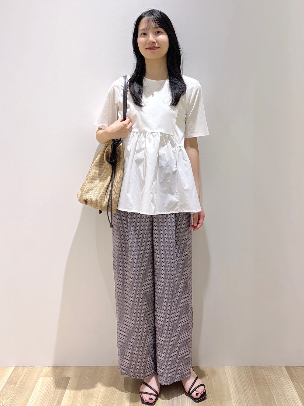 ブラウン系のサンダル、ベージュ系のトートバッグ、ホワイト系のTシャツ/カットソーを着用したレディースの春コーディネートの1枚目の写真