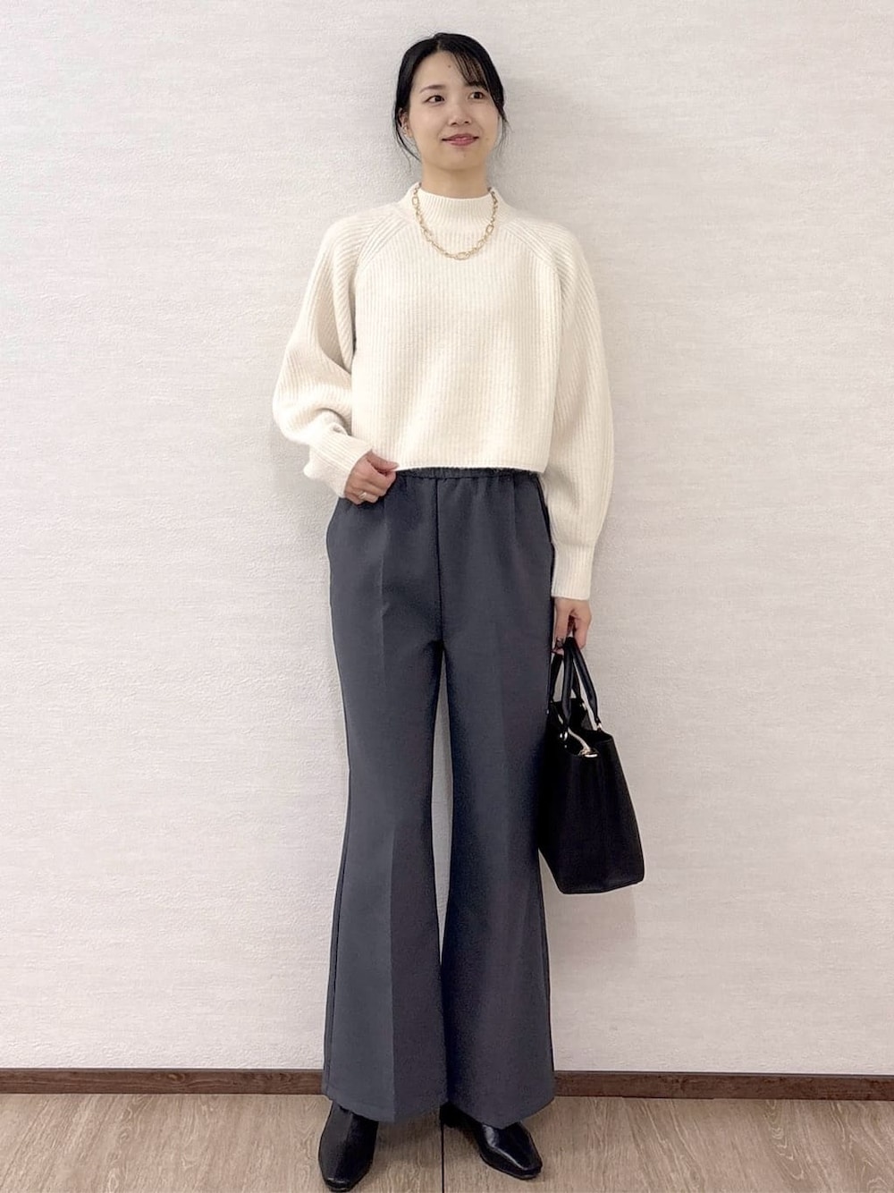 ホワイト系のニット/セーター、グレー系のその他パンツ、ブラック系のトートバッグを着用したレディースの冬コーディネートの1枚目の写真