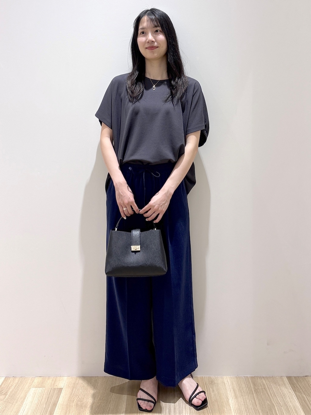 ブラック系のハンドバッグ、ベージュ系のショルダーバッグ、グレー系のTシャツ/カットソーを着用したレディースの春コーディネートの1枚目の写真