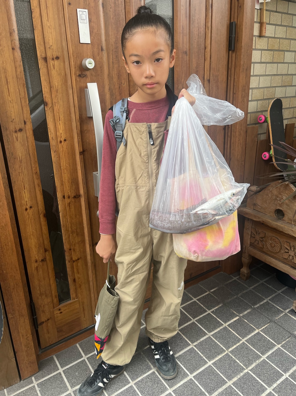 ブラック系のスニーカー、ベージュ系のサロペット/オーバーオール、ブラウン系のスウェットを着用したキッズの秋コーディネートの1枚目の写真