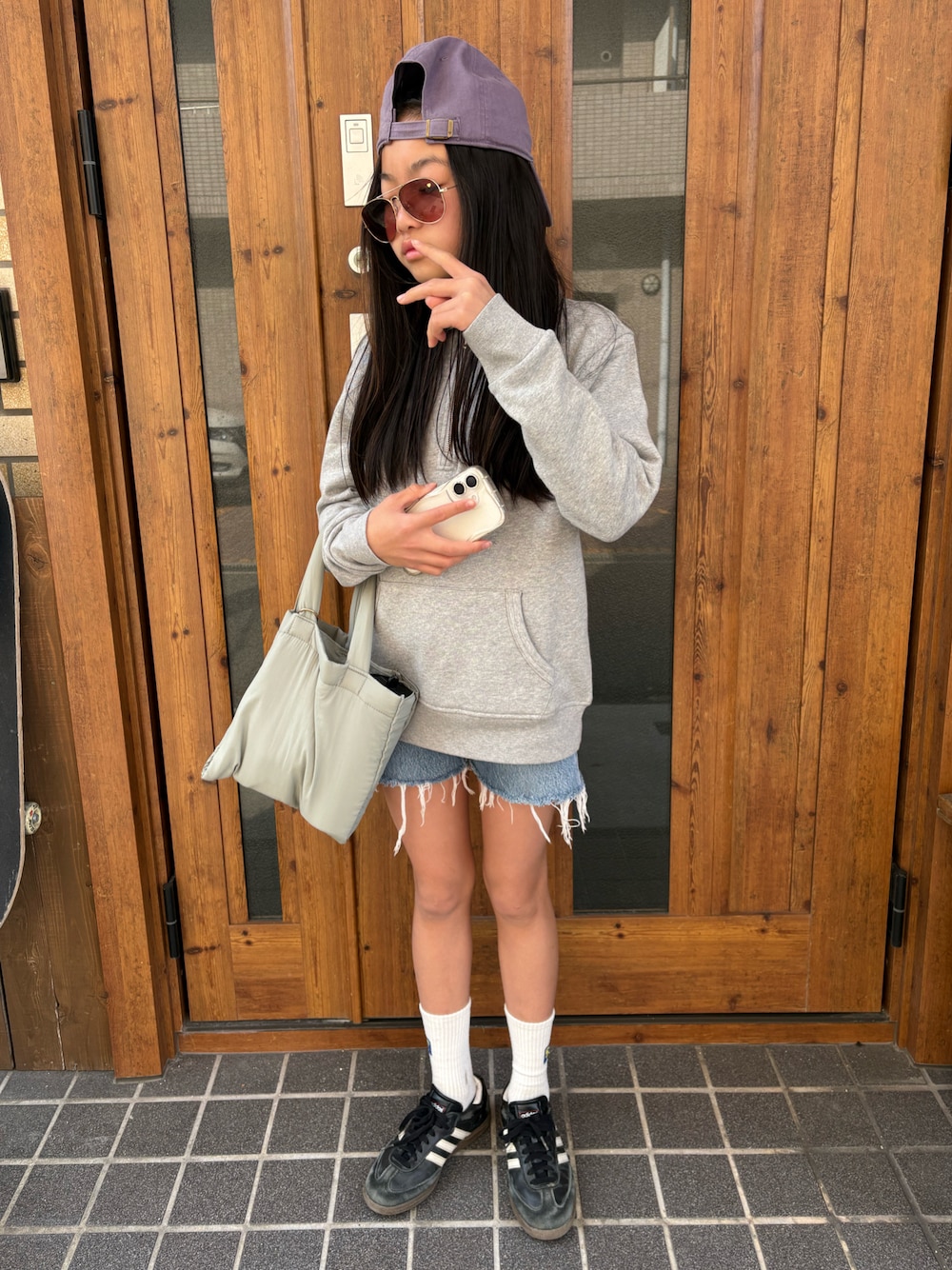 ブラック系のスニーカー、グレー系のスウェット、ブルー系のデニムパンツを着用したキッズの春コーディネートの1枚目の写真