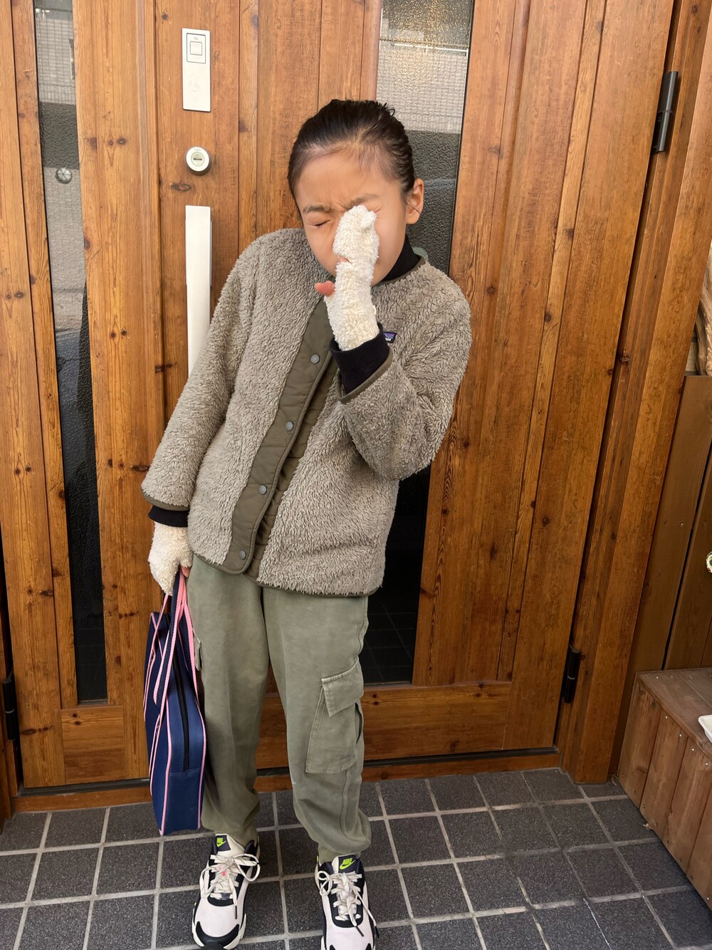 グリーン系のスウェットパンツ、ベージュ系のスニーカー、グリーン系のミリタリージャケットを着用したキッズの冬コーディネートの1枚目の写真