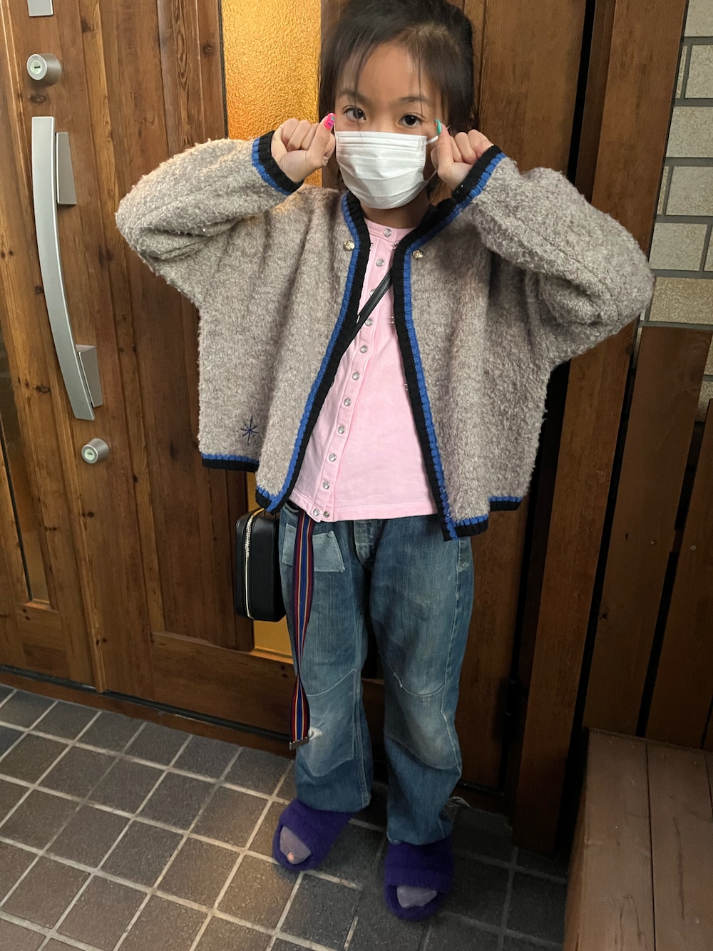 パープル系のサンダル、ブルー系のデニムパンツ、ピンク系のカーディガン/ボレロを着用したキッズの秋コーディネートの1枚目の写真