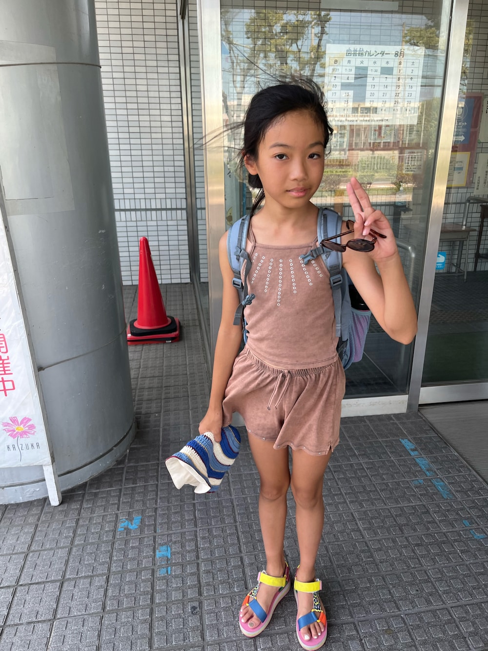 ピンク系のサンダル、ブラウン系のパンツ、ブラウン系のタンクトップを着用したキッズの夏コーディネートの1枚目の写真