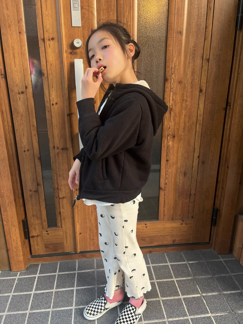ブラック系のスリッポン、ホワイト系のその他パンツ、ブラック系のパーカーを着用したキッズの春コーディネートの1枚目の写真