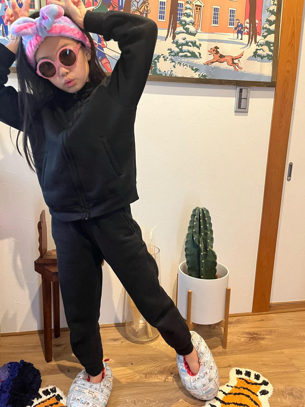 ブラック系のスウェットパンツ、ブラック系のパーカー、ピンク系のヘアバンドを着用したキッズの冬コーディネートの1枚目の写真