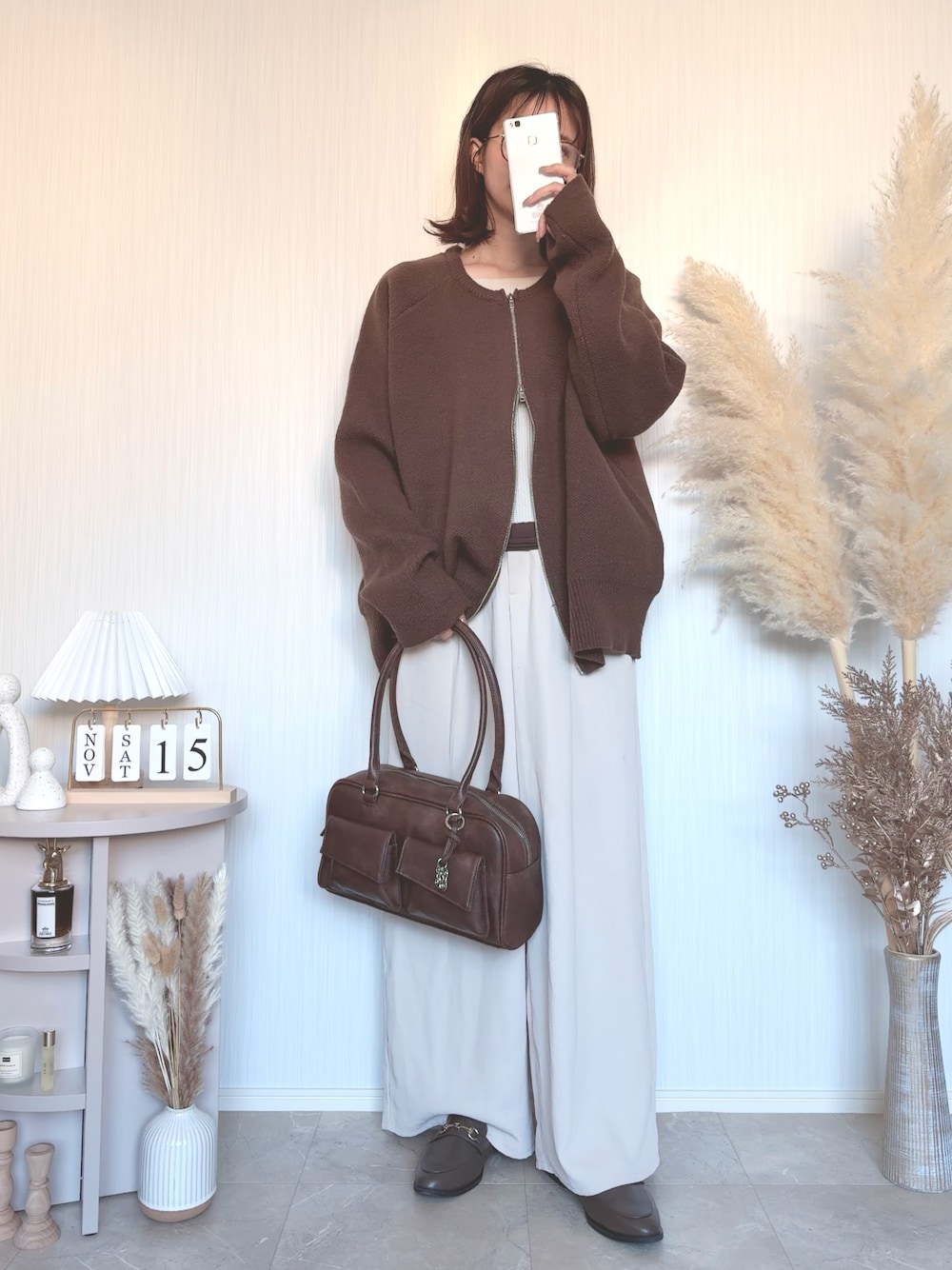 ブラウン系のショルダーバッグを着用したレディースの秋コーディネートの1枚目の写真
