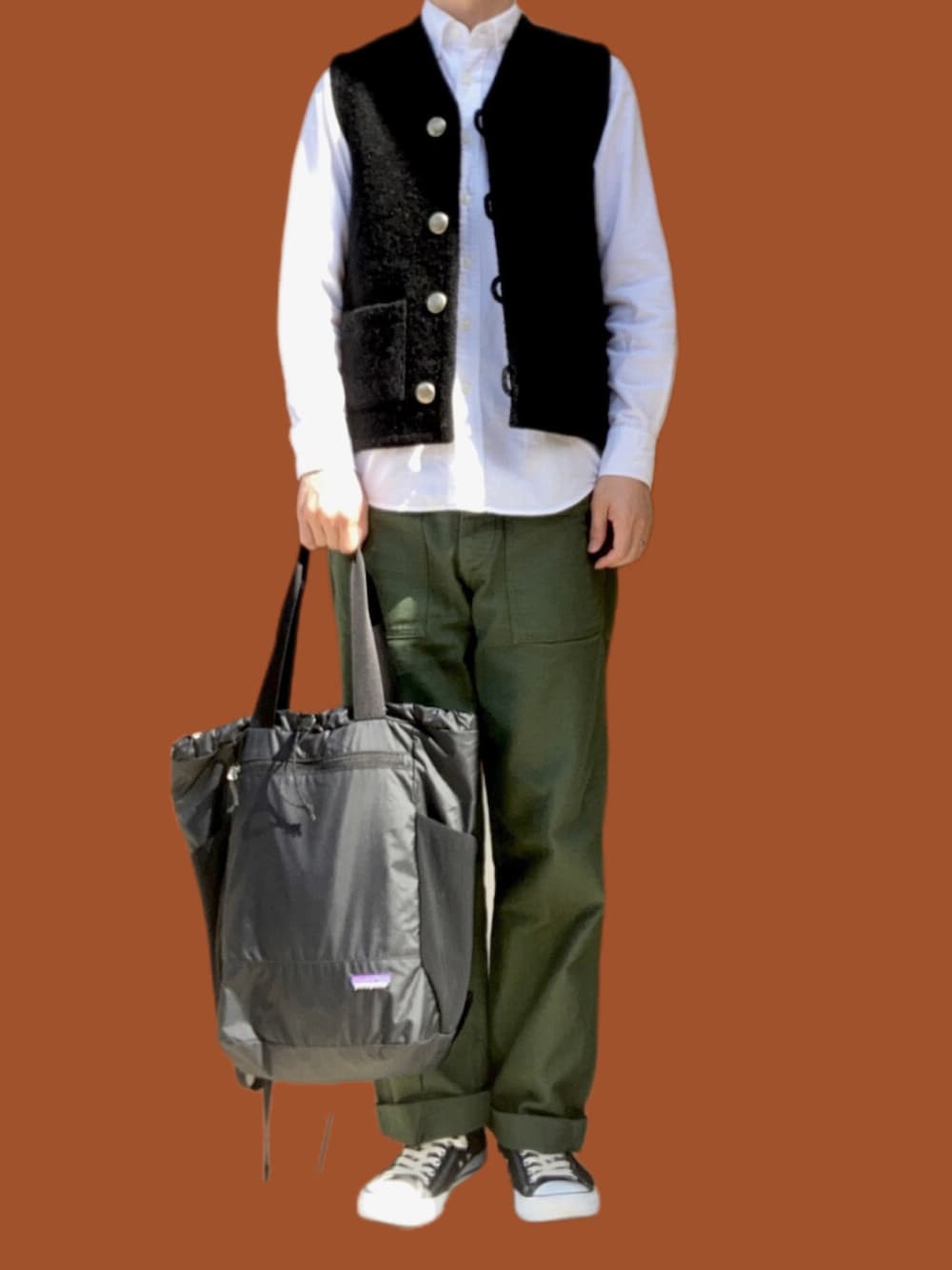 ブラック系のバックパック/リュック、ブラック系のスニーカー、グリーン系のパンツを着用したメンズの春コーディネートの1枚目の写真