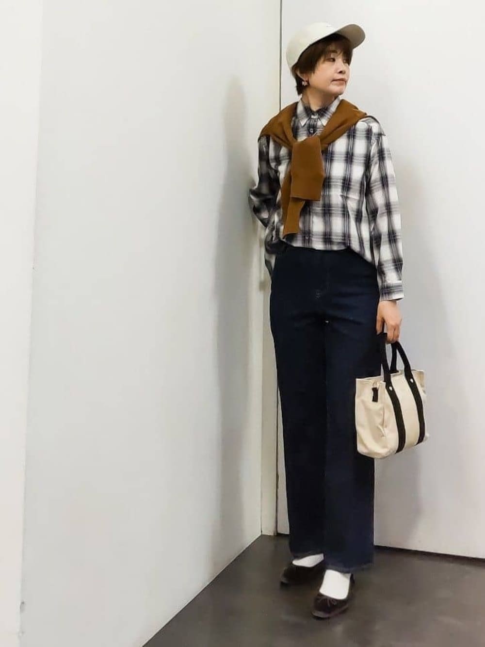イエロー系のカーディガン/ボレロ、ホワイト系のシャツ/ブラウス、ブラック系のタンクトップを着用したレディースの秋コーディネートの1枚目の写真