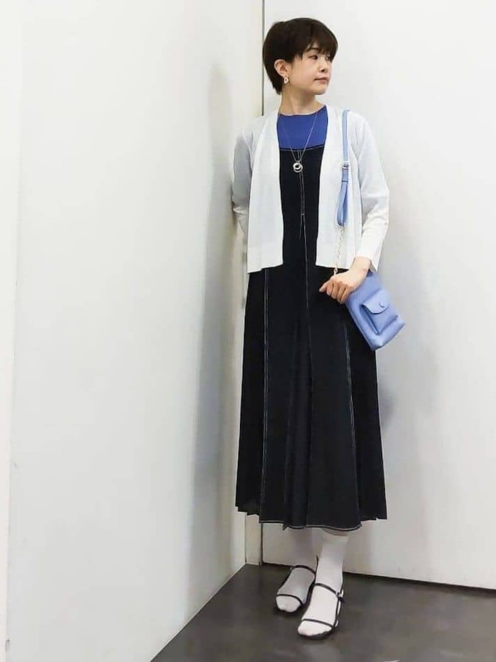 ホワイト系のカーディガン/ボレロ、ブルー系のワンピース、ブルー系のニット/セーターを着用したレディースの春コーディネートの1枚目の写真