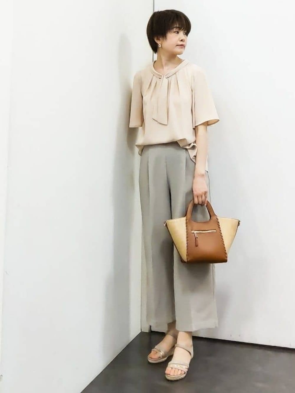 ピンク系のシャツ/ブラウス、ベージュ系のその他パンツ、イエロー系のトートバッグを着用したレディースの春コーディネートの1枚目の写真