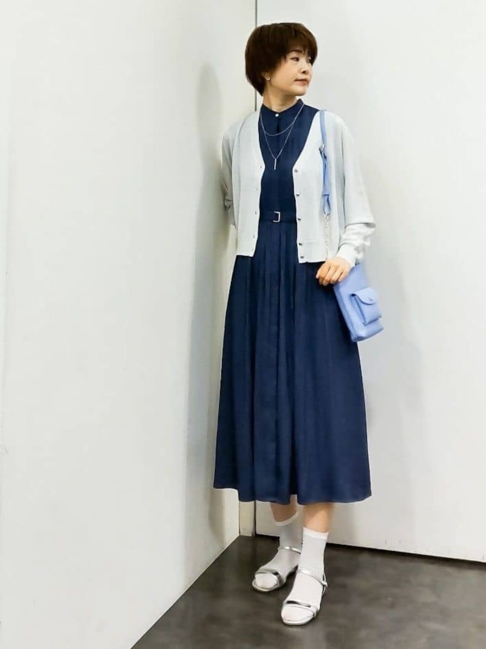 ホワイト系のカーディガン/ボレロ、ブルー系のワンピース、ブルー系のショルダーバッグを着用したレディースの春コーディネートの1枚目の写真