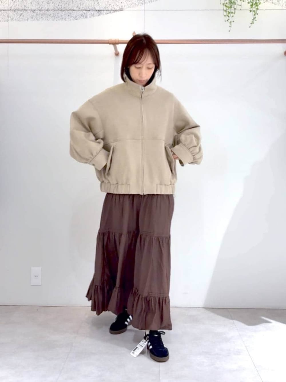 ブラック系のスニーカー、ベージュ系のブルゾンを着用したレディースの冬コーディネートの1枚目の写真