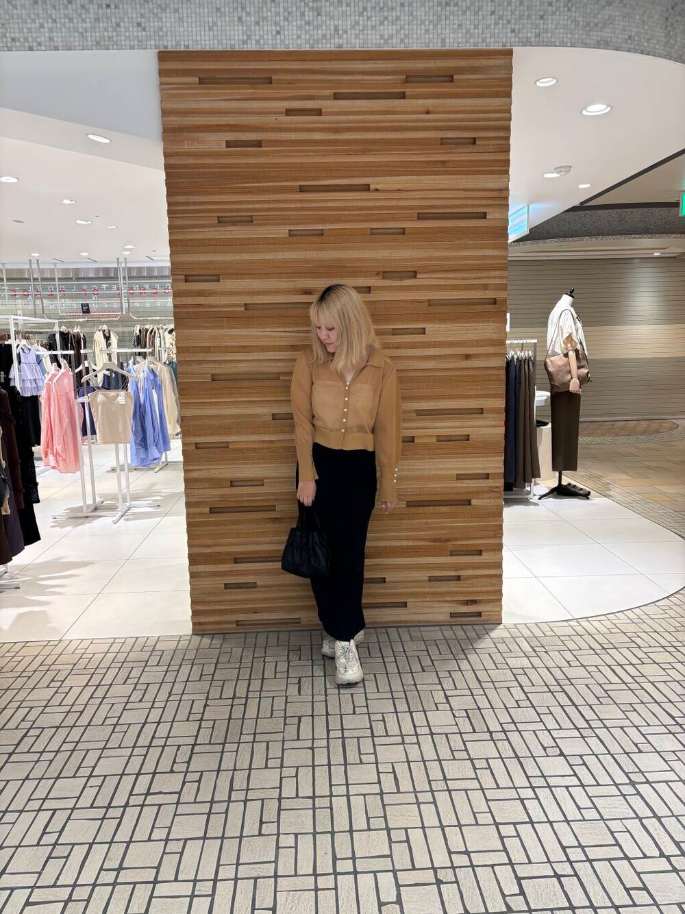 ブラック系のショルダーバッグ、ブラック系のスカート、イエロー系のカーディガン/ボレロを着用したレディースの夏コーディネートの1枚目の写真