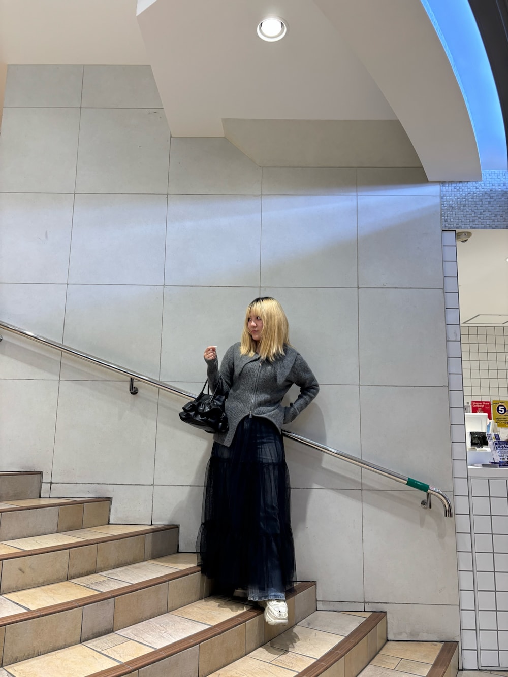 グレー系のカーディガン/ボレロ、ブルー系のその他パンツ、ブラック系のスカートを着用したレディースの冬コーディネートの1枚目の写真