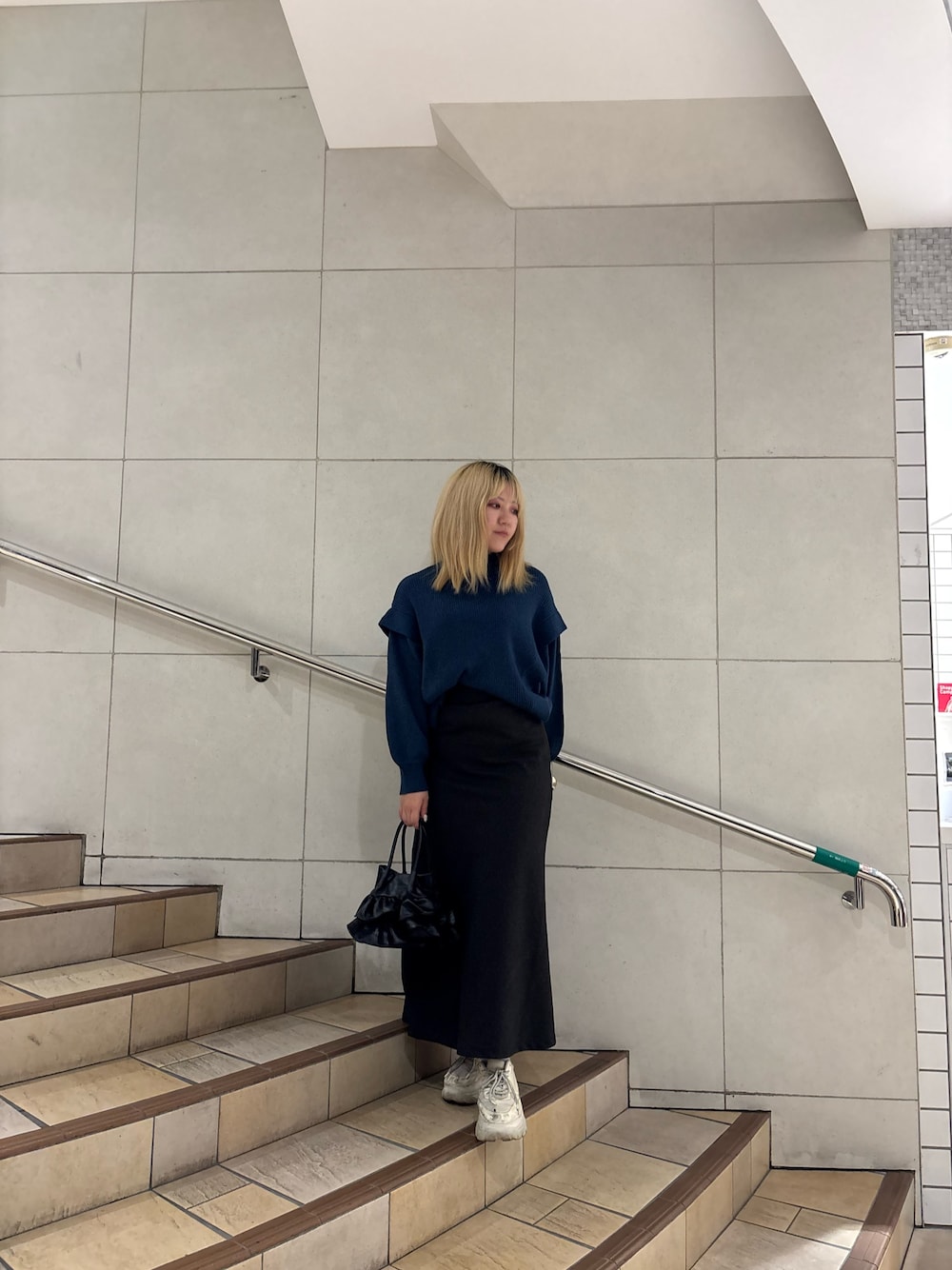 ブルー系のニット/セーター、グレー系のスカートを着用したレディースの冬コーディネートの1枚目の写真