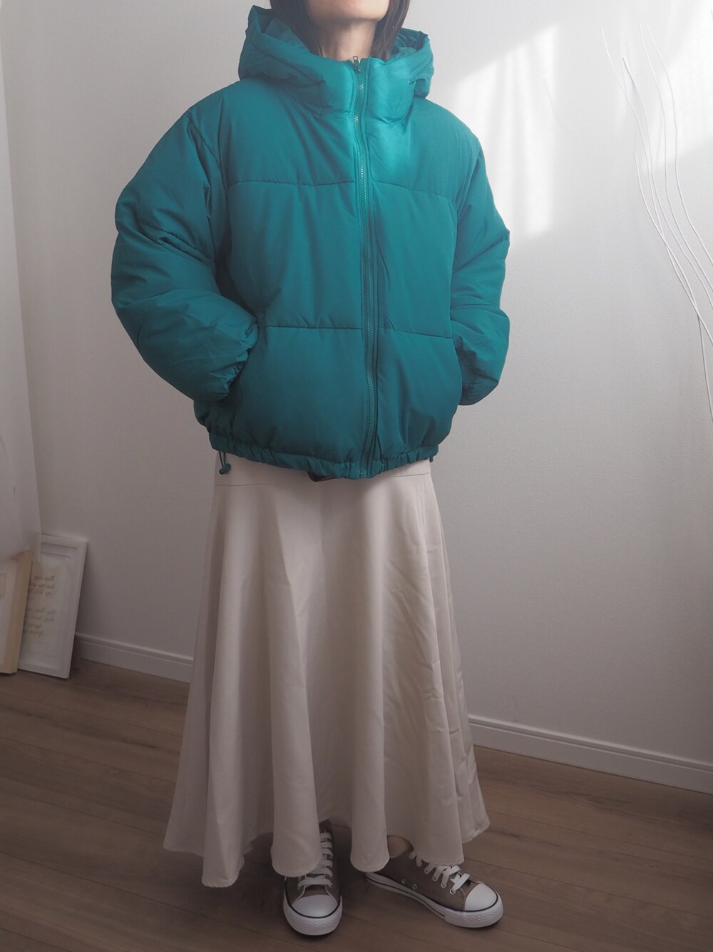 グリーン系のダウンジャケット/コート、ベージュ系のスカートを着用したレディースの冬コーディネートの1枚目の写真