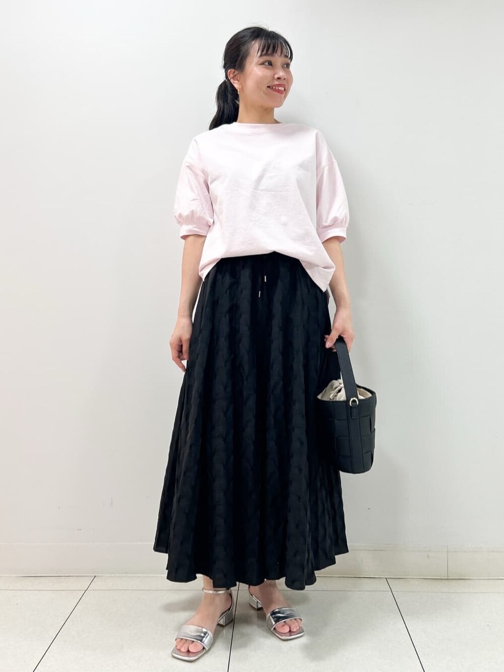 ピンク系のTシャツ/カットソー、ブラック系のスカート、ブラック系のショルダーバッグを着用したレディースの夏コーディネートの1枚目の写真