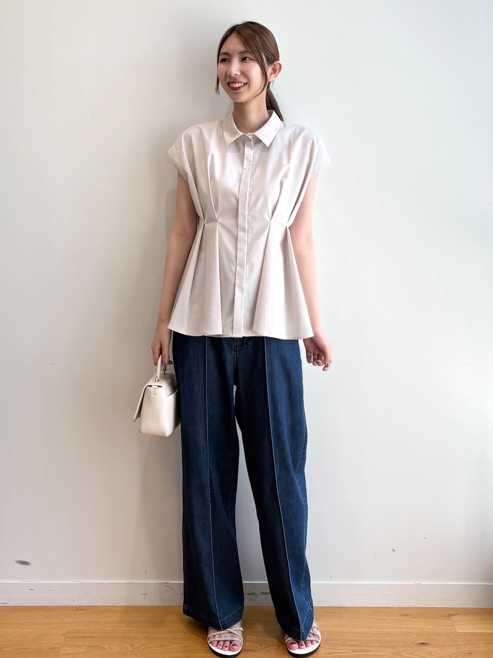 ベージュ系のシャツ/ブラウス、ブルー系のデニムパンツ、ホワイト系のショルダーバッグを着用したレディースの夏コーディネートの1枚目の写真