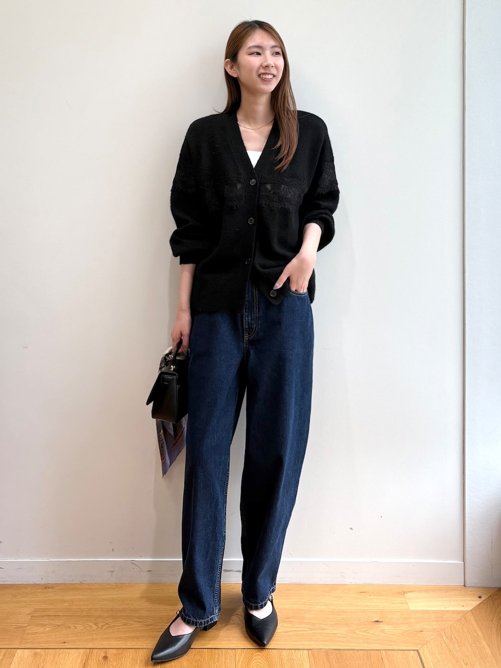 ブラック系のカーディガン/ボレロ、ブルー系のデニムパンツ、ブラック系のショルダーバッグを着用したレディースの夏コーディネートの1枚目の写真