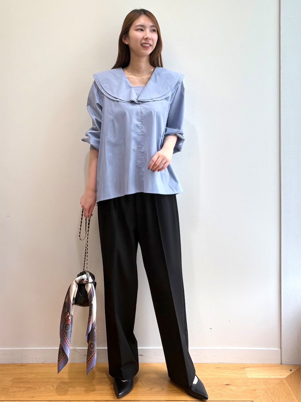 ブルー系のシャツ/ブラウス、ブラック系のショルダーバッグ、ブラック系のパンプスを着用したレディースの夏コーディネートの1枚目の写真