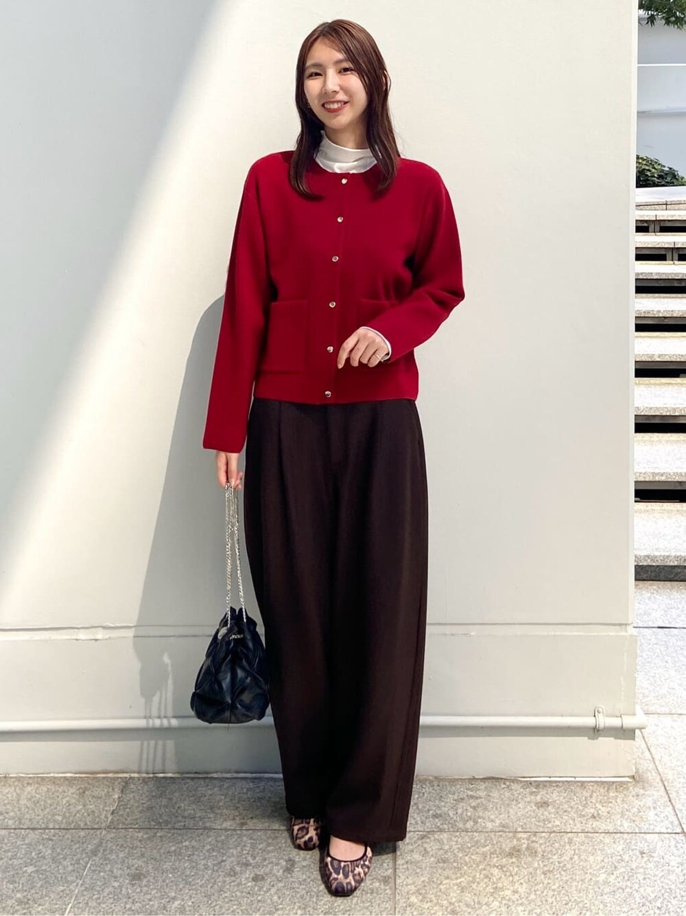 レッド系のカーディガン/ボレロ、ホワイト系のTシャツ/カットソー、ブラウン系のその他パンツを着用したレディースの秋コーディネートの1枚目の写真