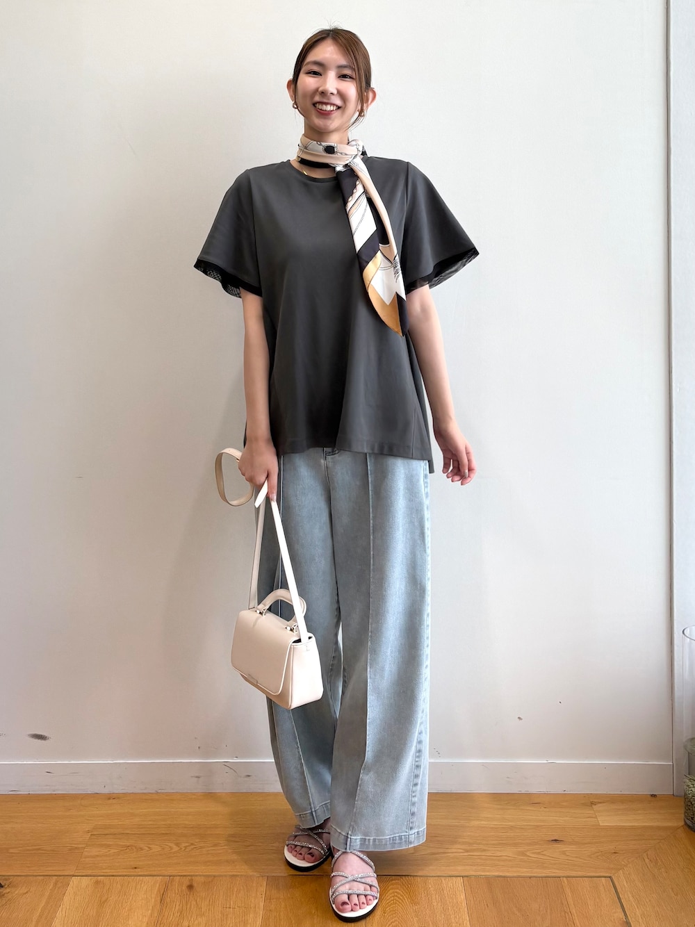 グレー系のTシャツ/カットソー、ブルー系のデニムパンツ、シルバー系のサンダルを着用したレディースの夏コーディネートの1枚目の写真