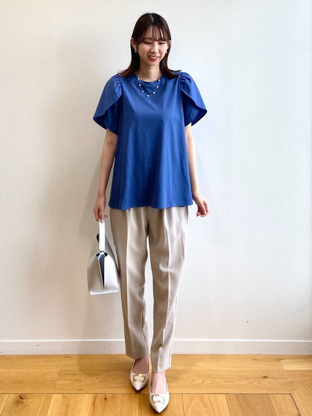 ブルー系のTシャツ/カットソー、ベージュ系のその他パンツ、グレー系のショルダーバッグを着用したレディースの春コーディネートの1枚目の写真