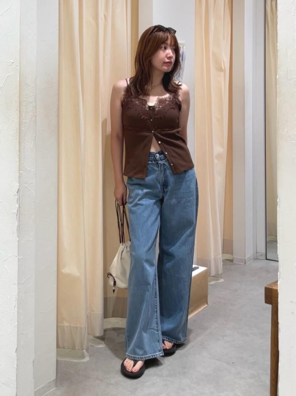 ブルー系のデニムパンツ、ホワイト系のショルダーバッグ、ブラウン系のTシャツ/カットソーを着用したレディースの夏コーディネートの1枚目の写真