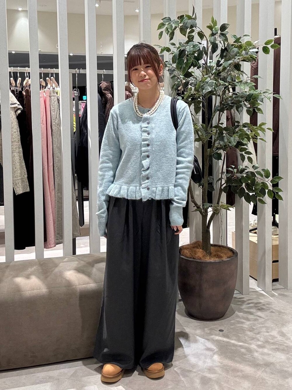 グレー系のその他パンツ、ベージュ系のブーツ、ブルー系のニット/セーターを着用したレディースの冬コーディネートの1枚目の写真