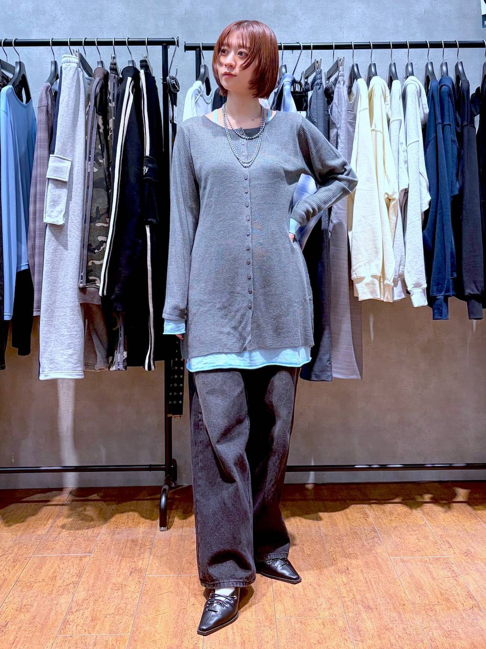 ブラック系のスラックス、ブラック系のサンダル、グレー系のチュニックを着用したレディースの春コーディネートの1枚目の写真