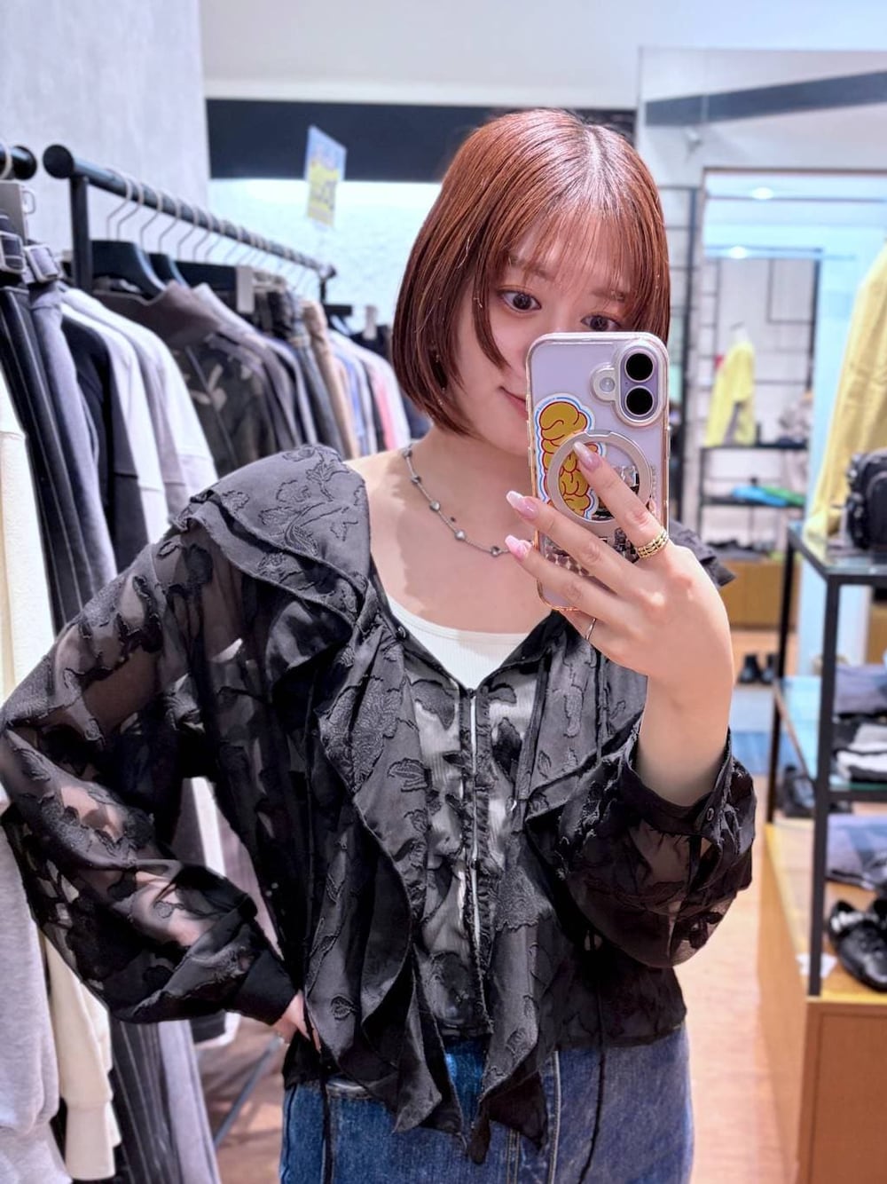 ホワイト系のキャミソール、ブルー系のデニムパンツ、ブラック系のサンダルを着用したレディースの春コーディネートの1枚目の写真