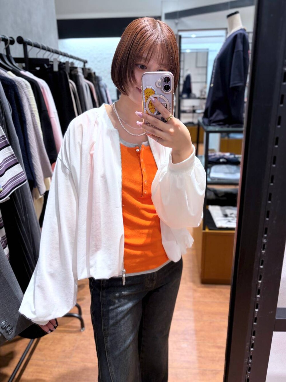 ブルー系のデニムパンツ、ホワイト系のブルゾン、ブラック系のサンダルを着用したレディースの春コーディネートの1枚目の写真