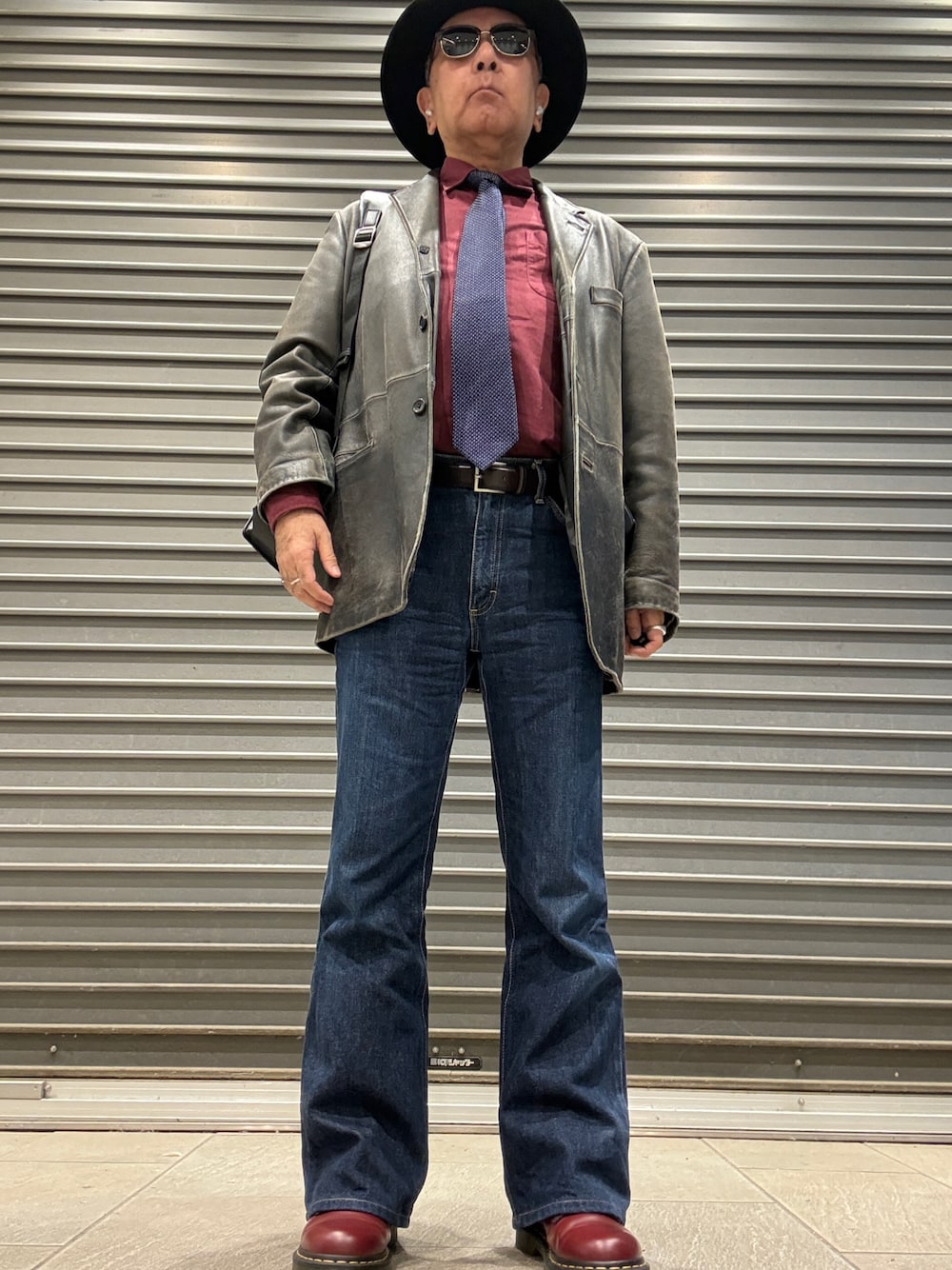 レッド系のブーツ、ブルー系のデニムパンツ、レッド系のシャツ/ブラウスを着用したメンズの秋コーディネートの1枚目の写真