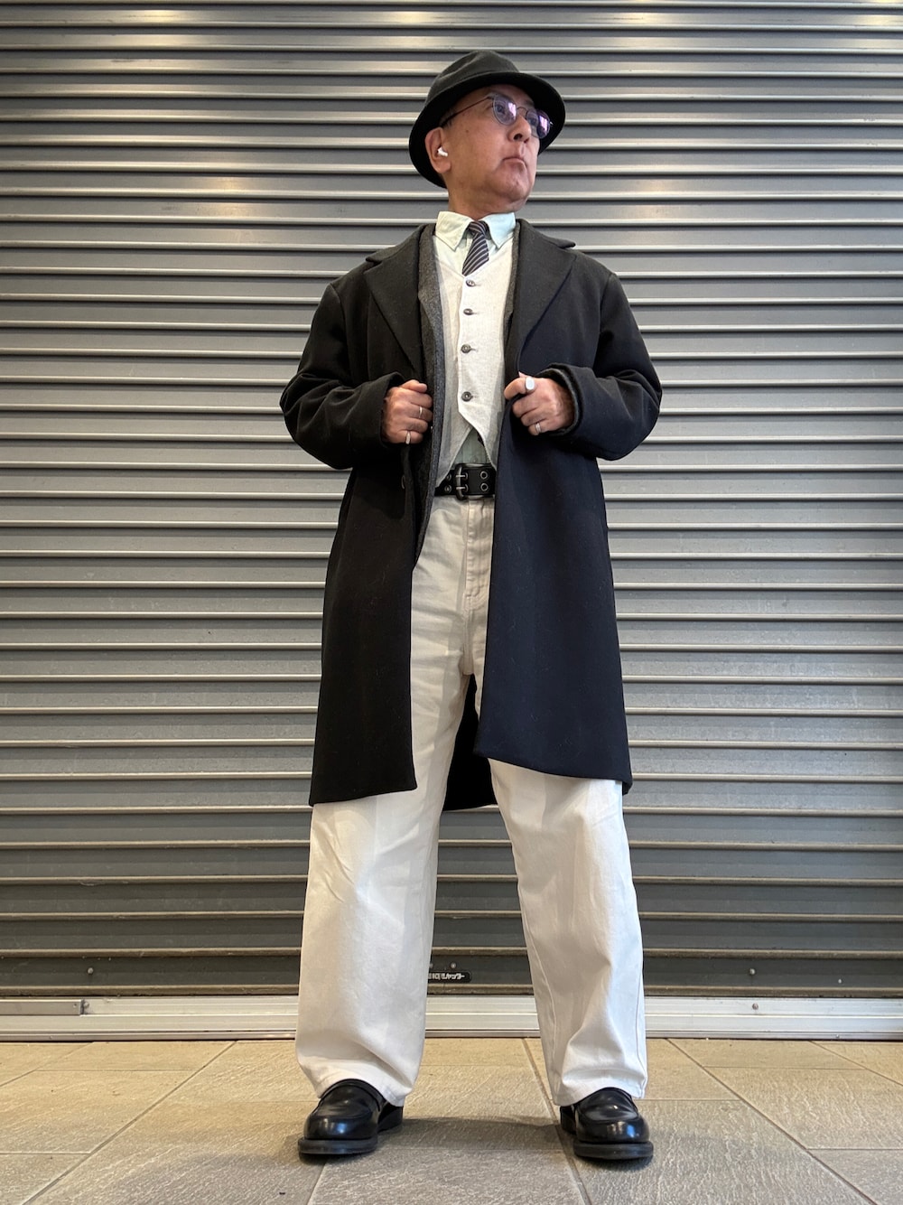 グリーン系のシャツ/ブラウス、ブルー系のネクタイ、ホワイト系のベストを着用したメンズの冬コーディネートの1枚目の写真