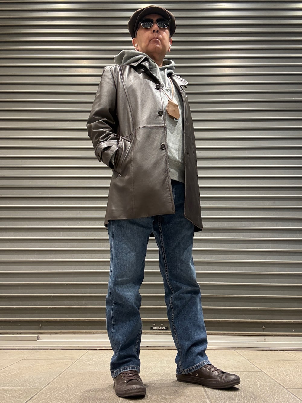 ブラウン系のトレンチコート、グレー系のパーカー、ブルー系のデニムパンツを着用したメンズの冬コーディネートの1枚目の写真