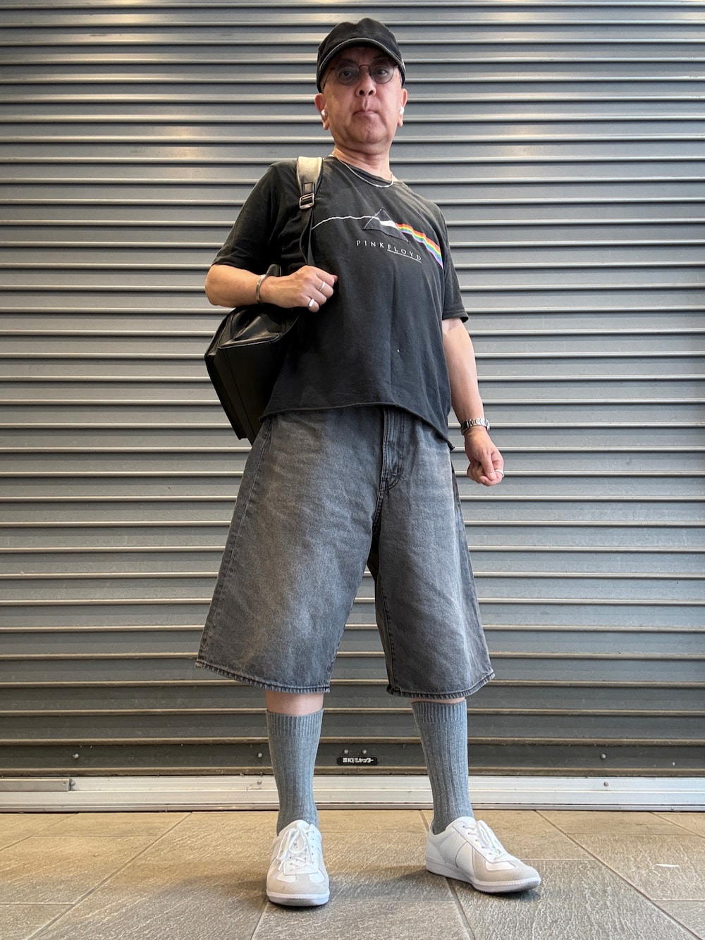 グレー系のデニムパンツ、ブラック系のTシャツ/カットソー、ブラック系のバックパック/リュックを着用したメンズの夏コーディネートの1枚目の写真