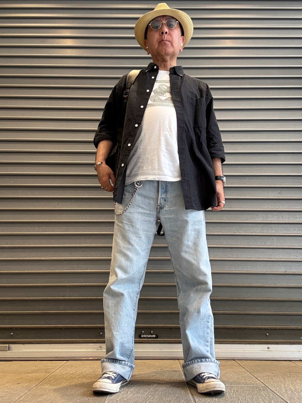 ホワイト系のTシャツ/カットソー、ブラック系のシャツ/ブラウス、ブルー系のデニムパンツを着用したメンズの春コーディネートの1枚目の写真