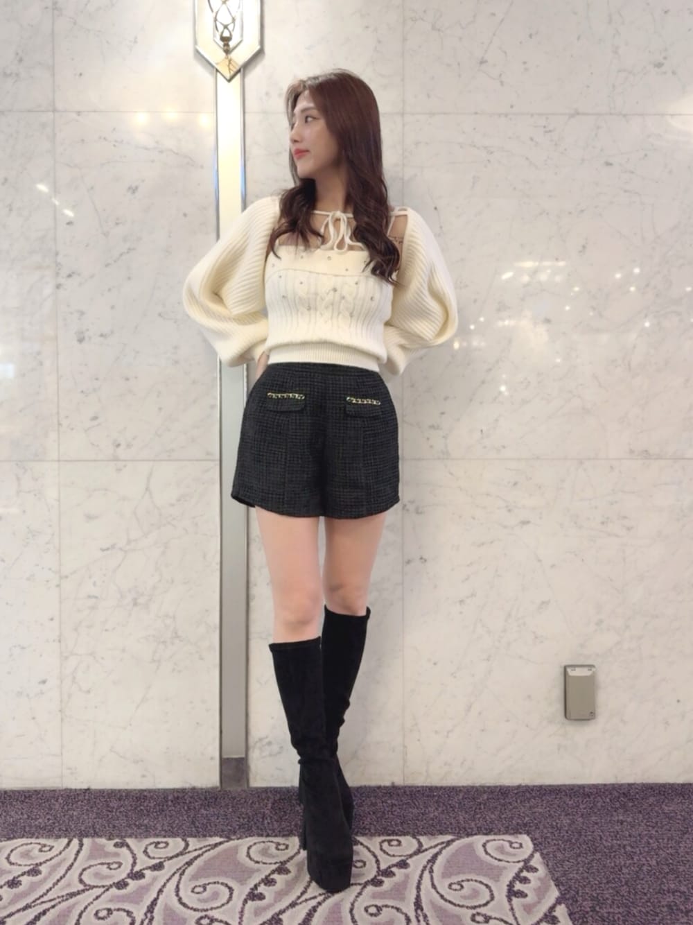 ブラック系のその他パンツ、ホワイト系のニット/セーター、ブラック系のブーツを着用したレディースの秋コーディネートの1枚目の写真