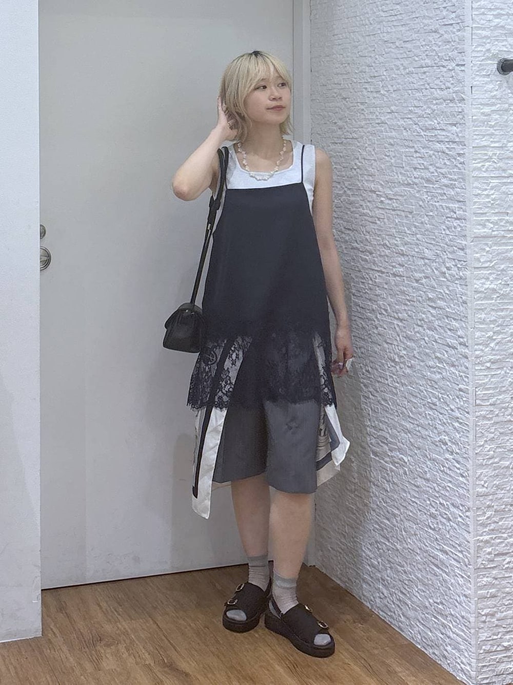 ブラック系のショルダーバッグ、グレー系のタンクトップ、ブラック系のサンダルを着用したレディースの夏コーディネートの1枚目の写真