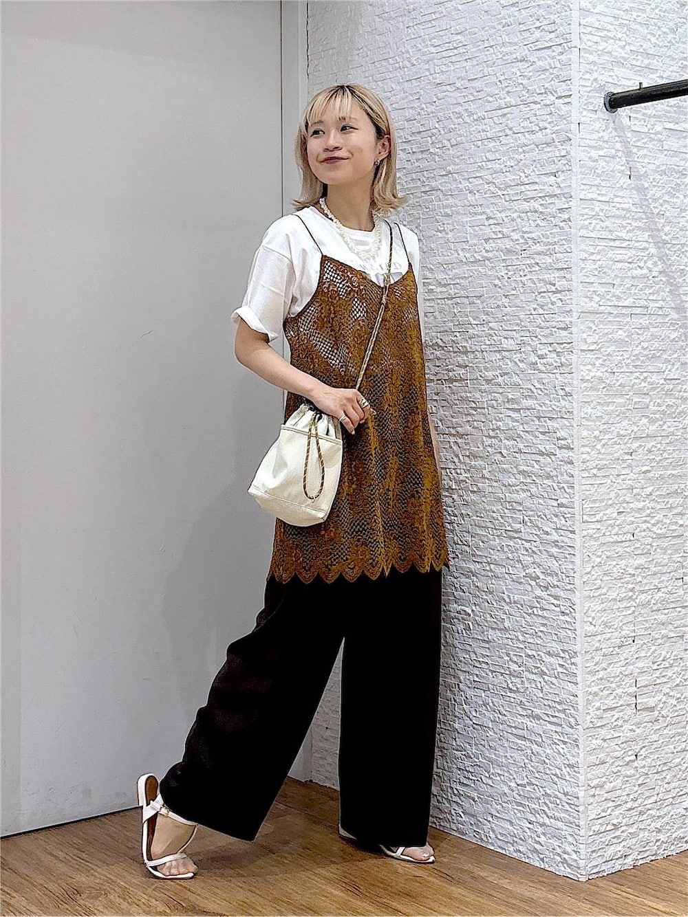 オレンジ系のキャミソール、ホワイト系のTシャツ/カットソー、ベージュ系のボディバッグ/ウエストポーチを着用したレディースの夏コーディネートの1枚目の写真